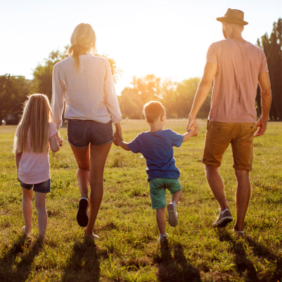 Image of a family walking toward a sunset.
