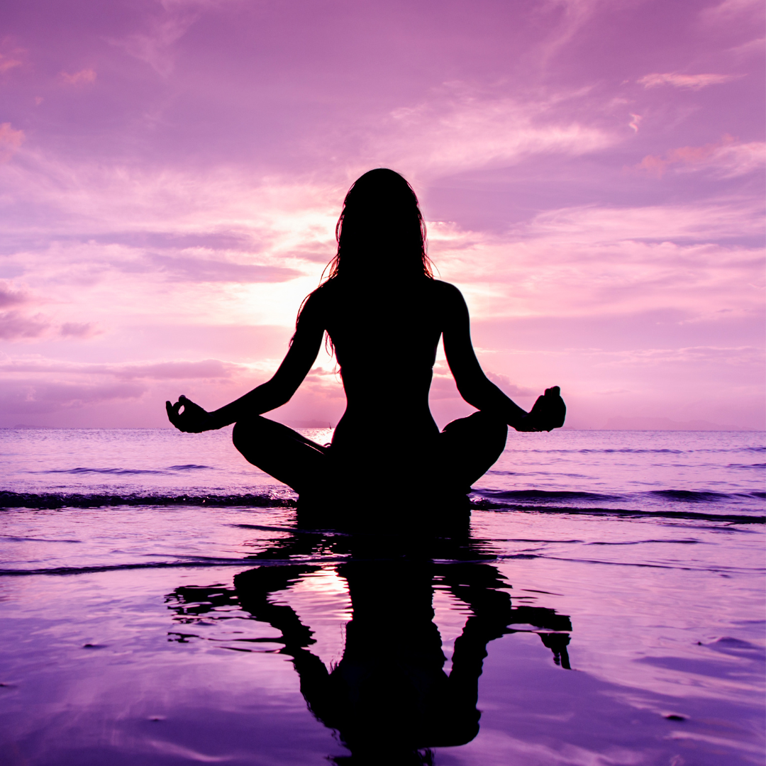 Image of a woman by the water meditating