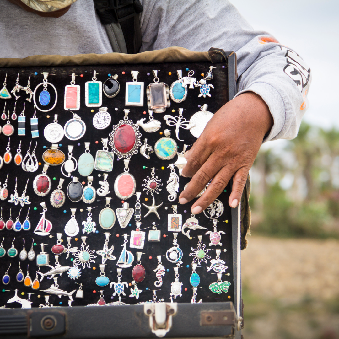 Image of jewelry vendor holding up a case of jewelry