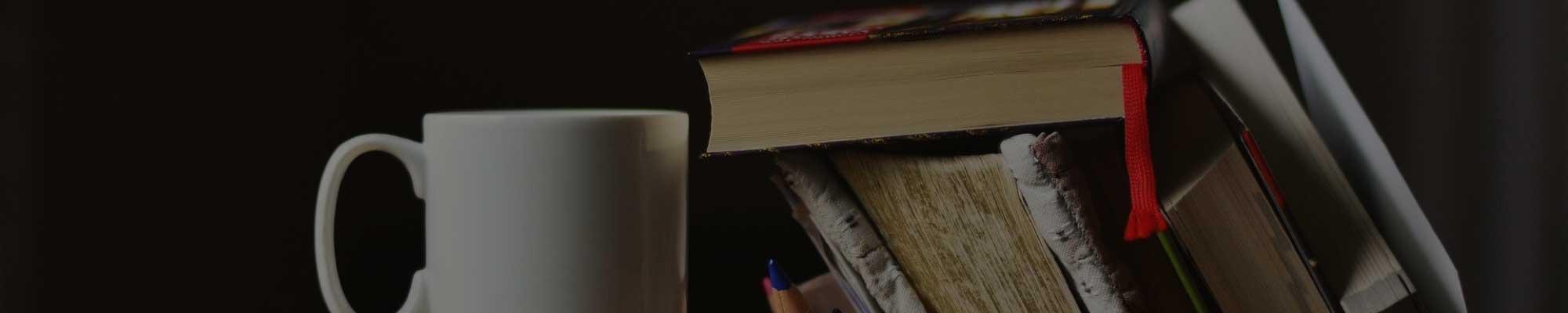 Image of books with a coffee cup next to it.