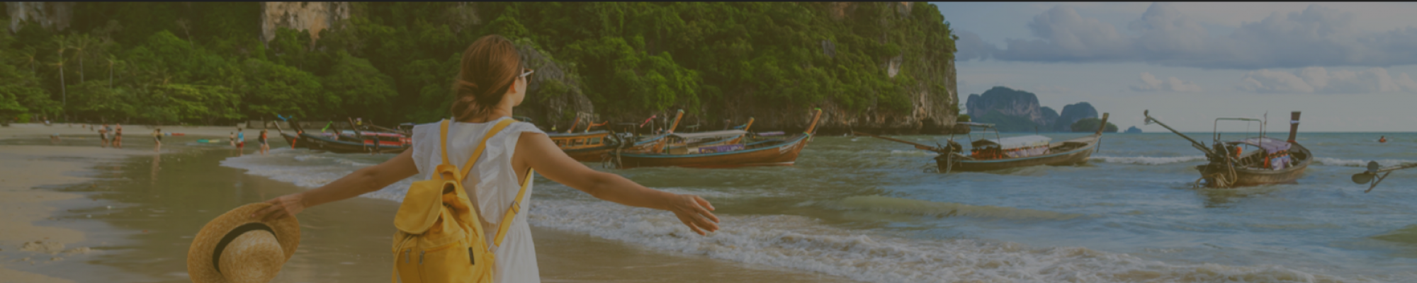 Image of woman on beach with boats in the background