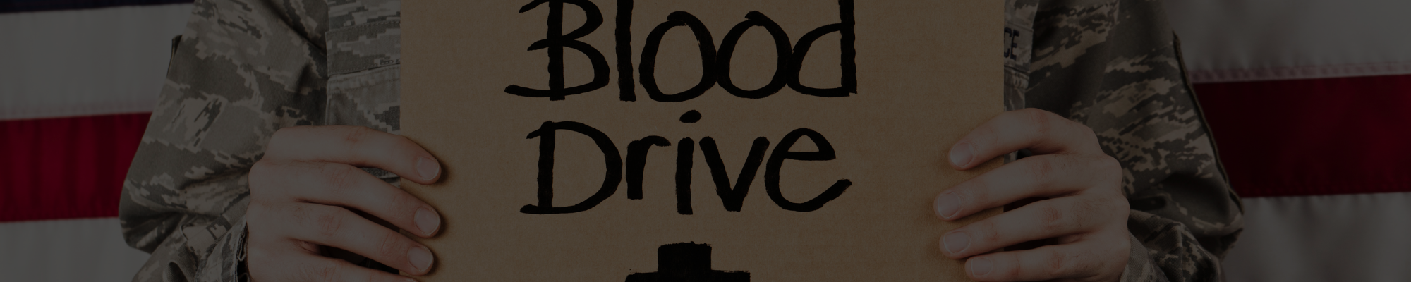 Image of man holding a sign that says "blood drive"