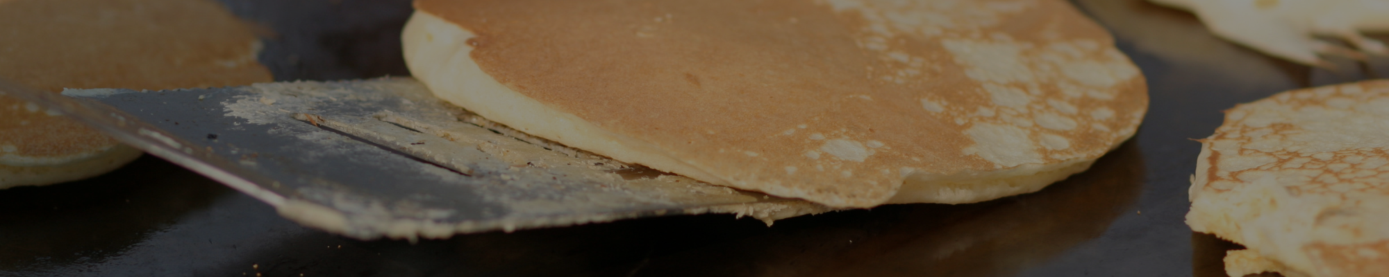 Image of a pancake being flipped on a griddle